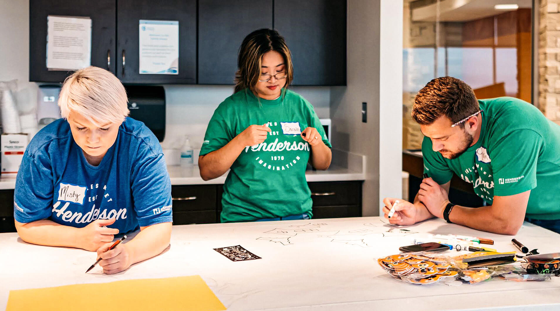 Three employees working on a give back opportunity in the Dallas office.