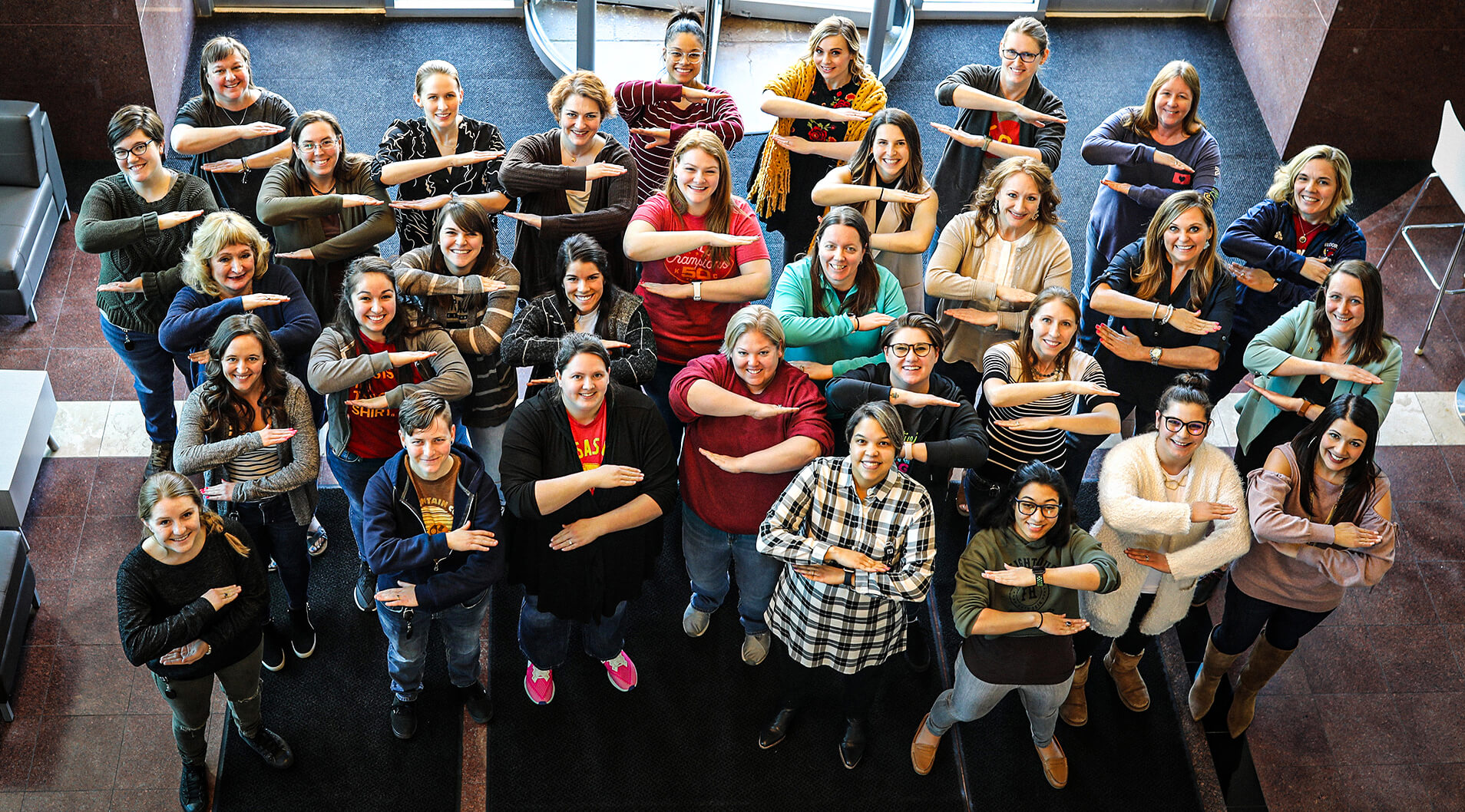 A group of female Henderson employee posing for the women's people resource group, Empower.