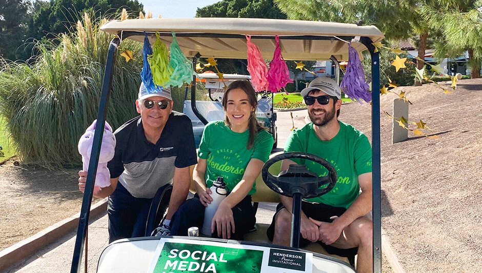 Three engineers chatting in a golf cart at the client golf tournament.