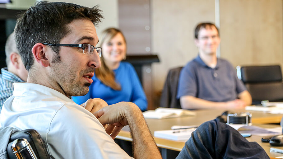 Ryan Starkovich speaking about Henderson Engineers expertise to other leaders around a conference table.