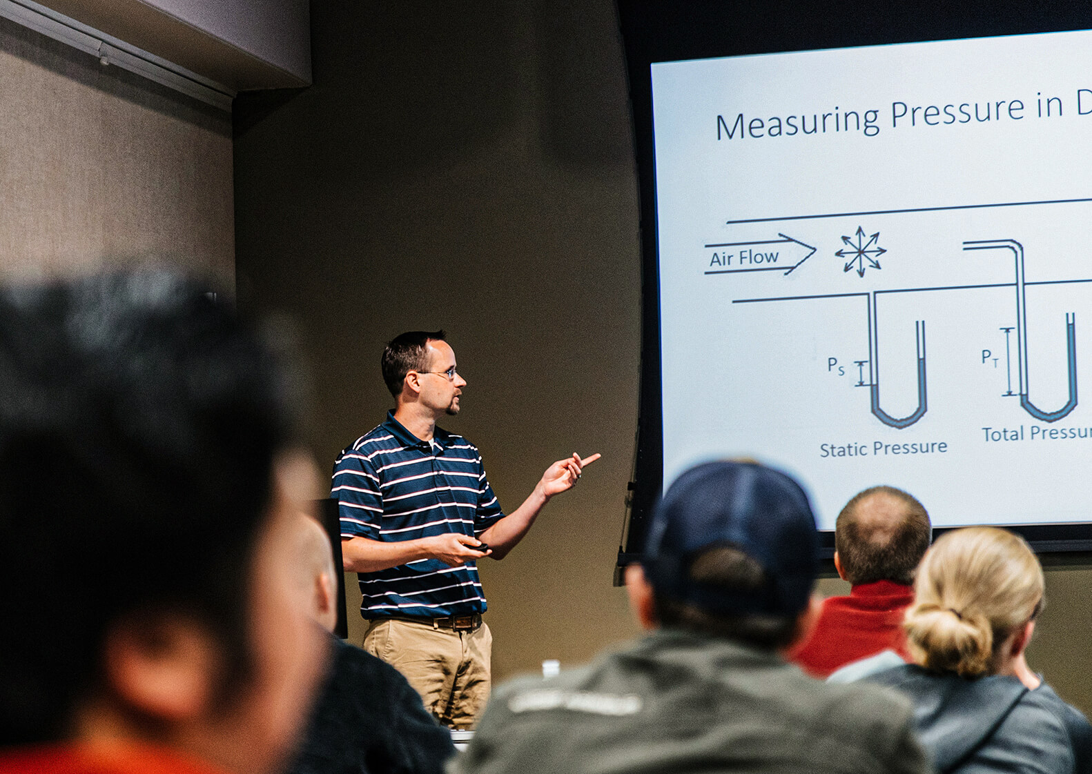 A Henderson Engineers employee presenting to a room full of other engineers.