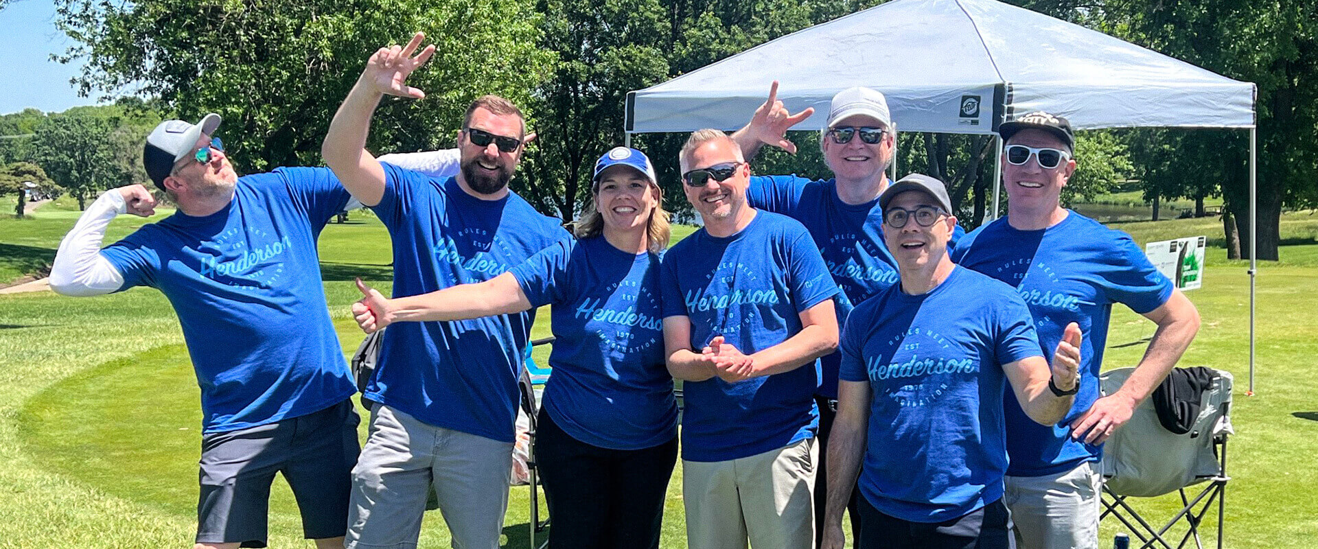 Group of Henderson Engineers executives laughing together at the client golf tournament.