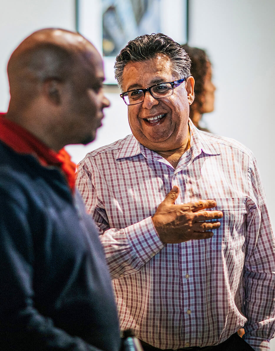 Omid Mottahed smiling and chatting with another Henderson Engineers employee.