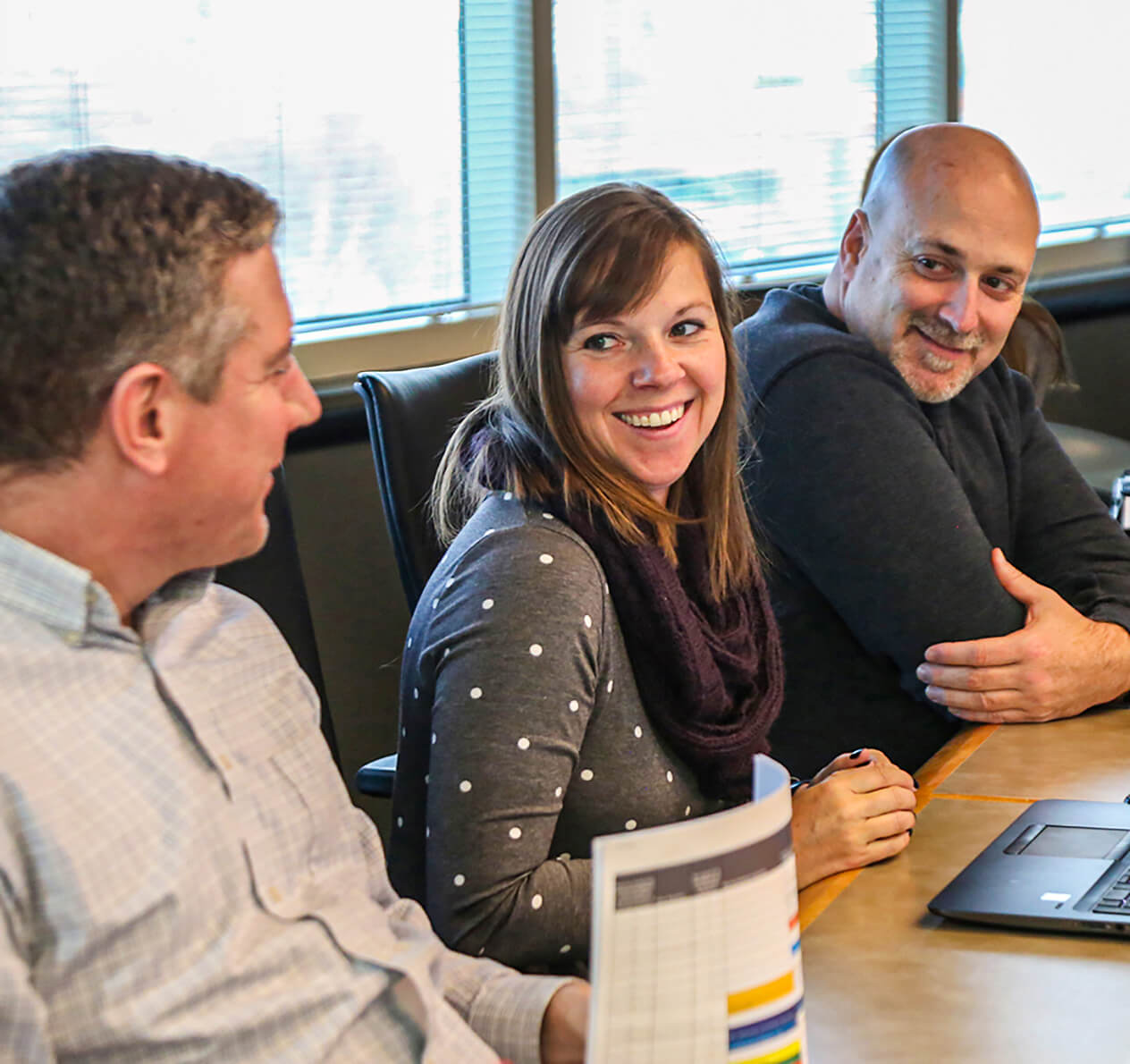 Angie Grant chatting with Tony Welter on a break at a conference room table.